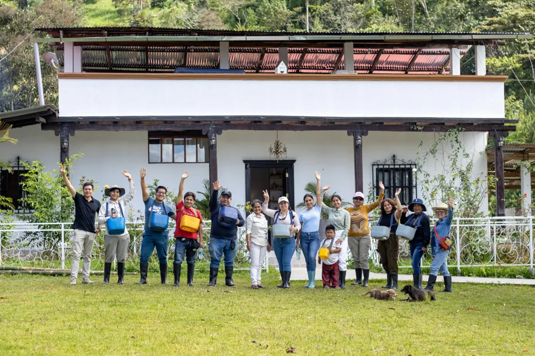 Equipo y visitantes reunidos frente a la casa de la finca Divino Niño Jesús
